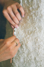 fastening buttons on a wedding dress 