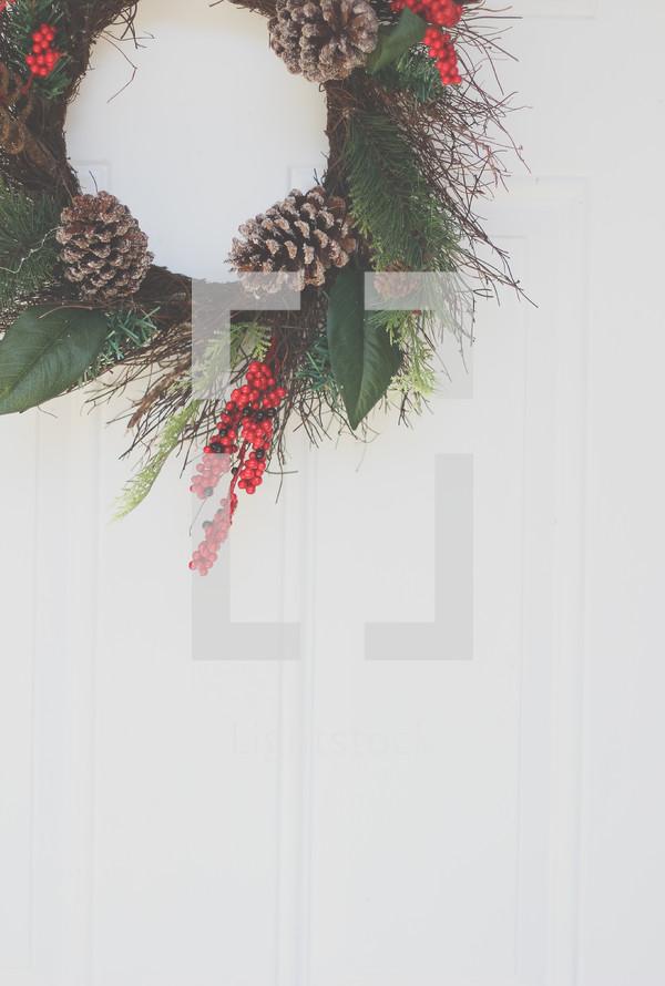 a Christmas wreath hanging on a front door 