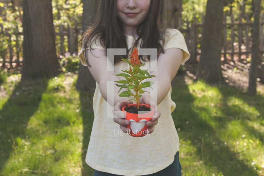 a girl holding a flower pot 