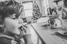 a kid with hot cocoa eating at the table at Christmas 
