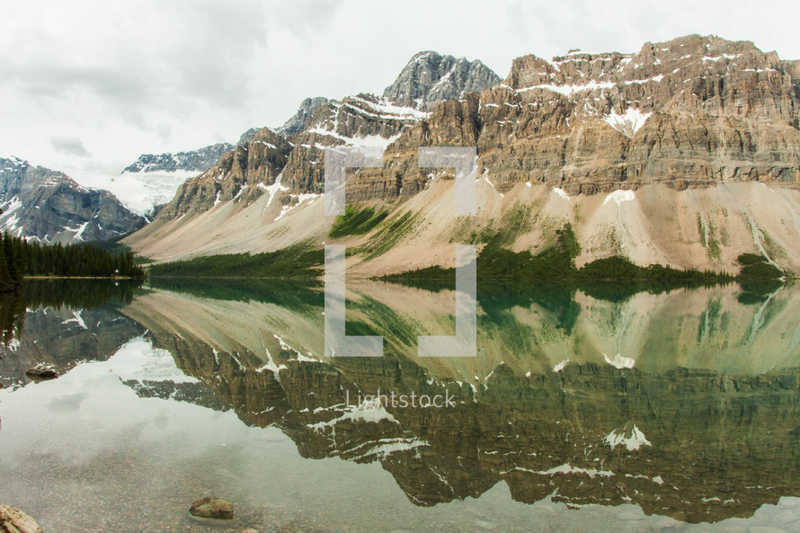 reflection of mountain peaks in lake water 