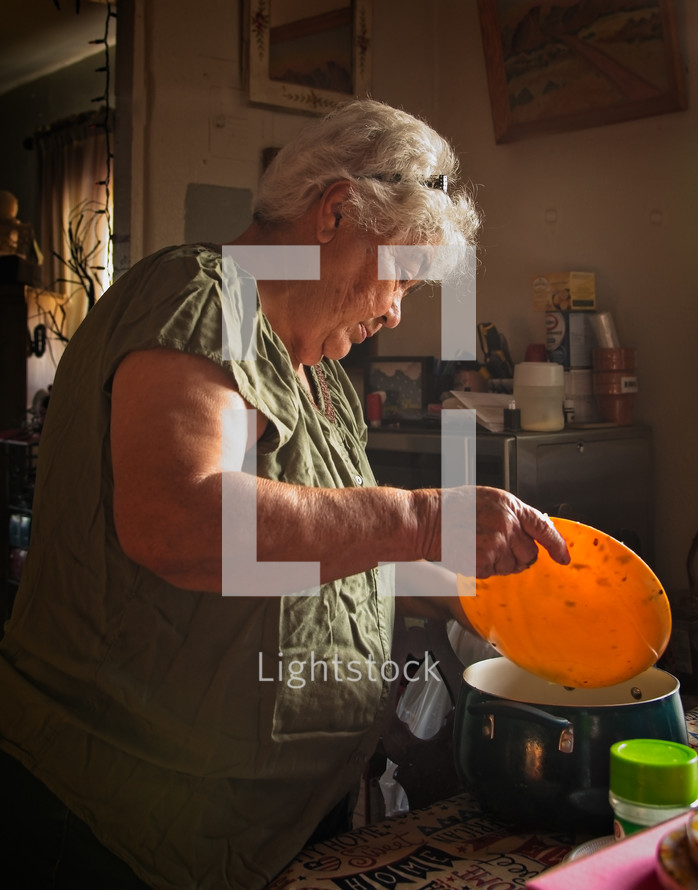 elderly woman chopping pepper 
