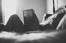 a child reading a book in bed