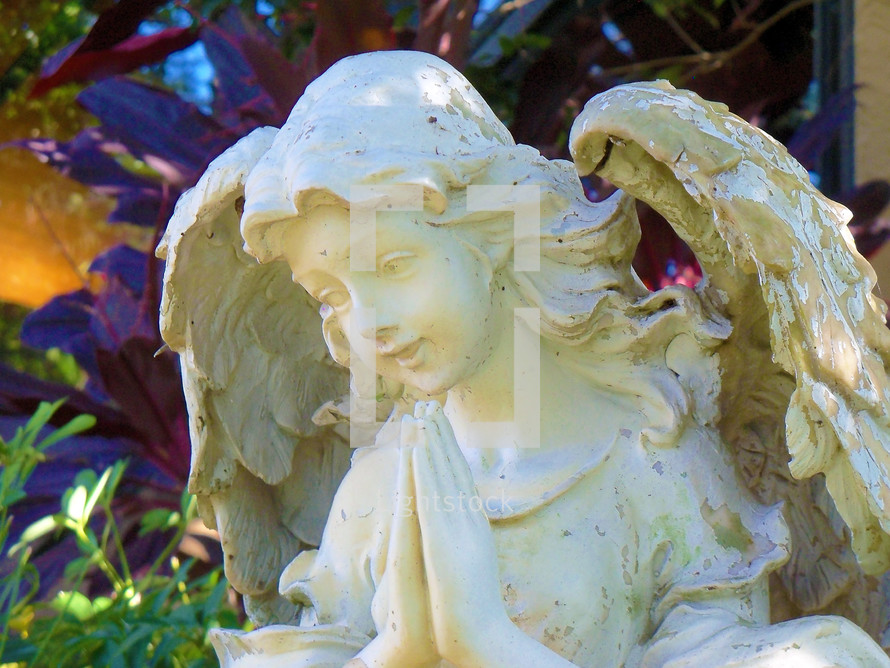 Distressed angel statue in a garden