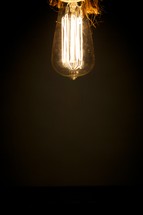 An old-fashioned lightbulb hanging from a ceiling