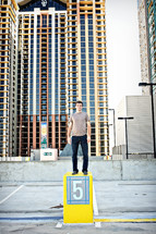 A man standing on a pedestal among tall buildings.