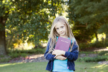 Young girl with Bible outdoors