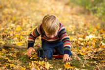 toddler boy playing in the grass 