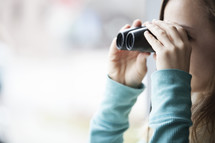 woman looking through binoculars 
