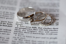 wedding rings on the pages of a Bible, love never fails 
