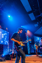 A guitarist performing on a stage worship service electric
