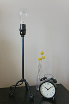 a lamp and alarm clock on a night stand 