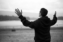 man with hands raised in praise and worship to God