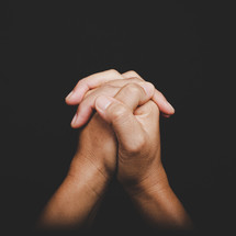 Close up of Asian woman's hands folded together in prayer