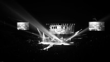 Spotlights shining on a stage during a concert.