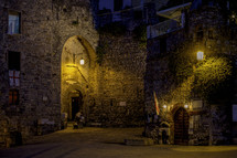 a couple walking together through historic streets at night 