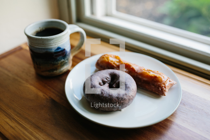 donut on a plate by a window 