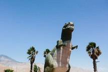 Tyrannosaurus Rex dinosaur sculpture and palm trees 
