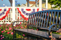 bench in a park with patriotic banner on a gazebo 