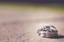 engagement ring and wedding band on concrete 