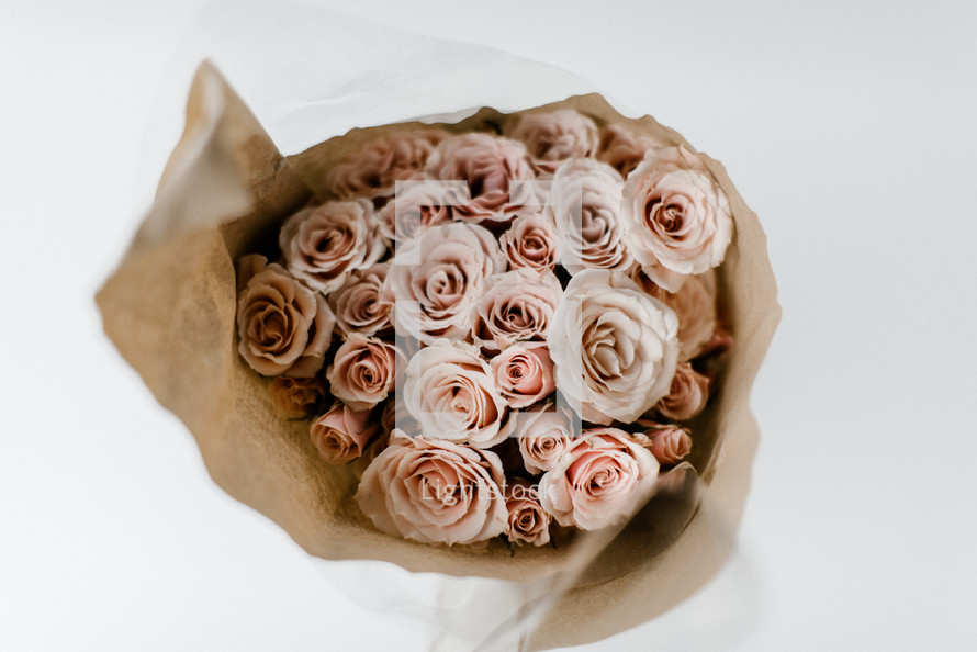 bouquet of pink roses in brown paper 