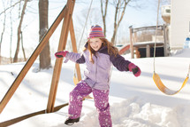 kids playing on a swing set in the snow 