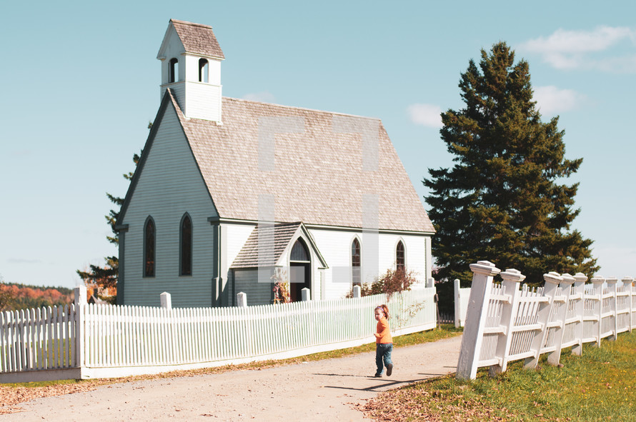 child running towards a small white church 