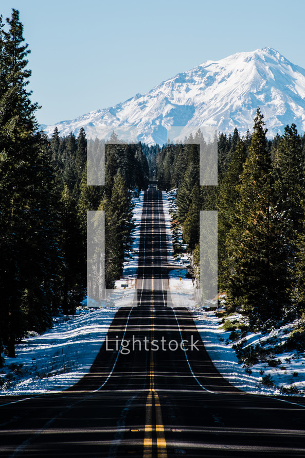 road leading to a snow capped mountain 