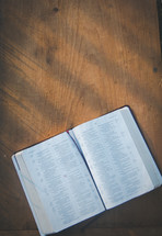 open Bible on a wood floor 