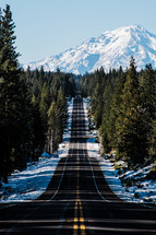 road leading to a snow capped mountain 
