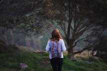 a young woman walking alone in a forest 