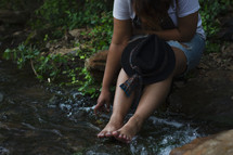 a woman sitting with her feet in water 