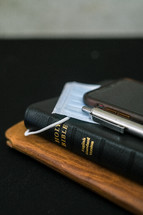journal, Bible, phone, and surgical mask 