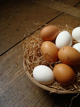 Natural eggs in a basket on a wood floor.