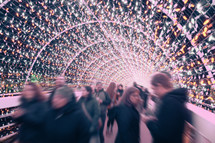 blurry image of people gathered to view Christmas lights 