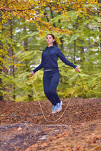 woman jumping rope in a forest 