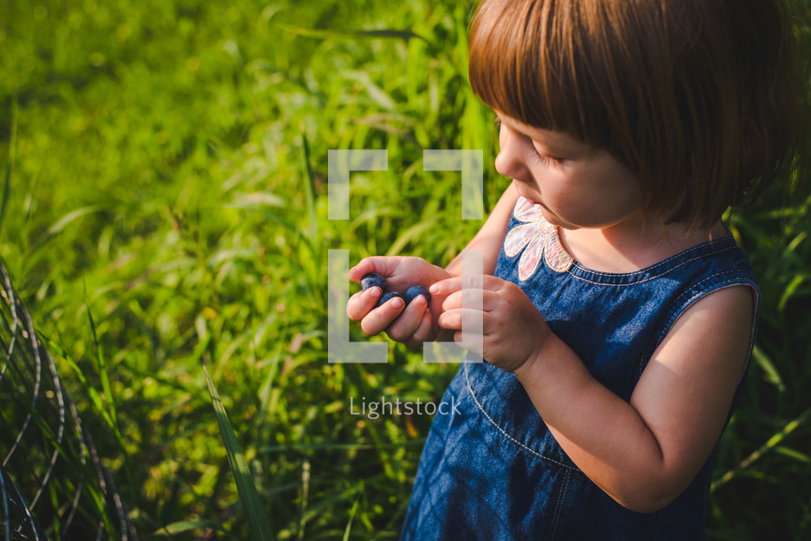 toddler girl eating blueberries 