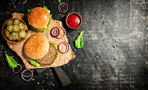 A burger on a stone board on a table. On a black background. High quality photo