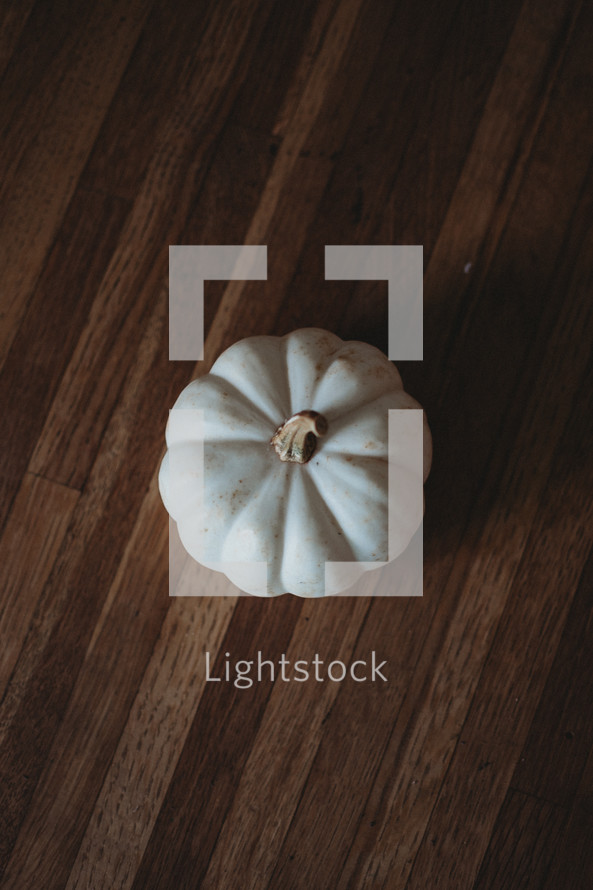 white pumpkin on a wood table 