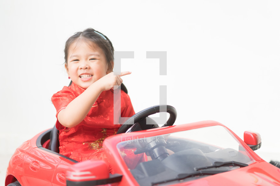 little girl in a toy car 