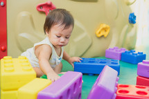infant playing with blocks 