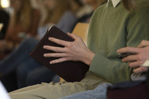 Close up of people holding Bibles on a row