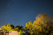 stars in the night sky over a house 