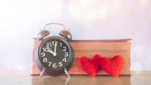 Alarm clock, red hearts, and Bible 