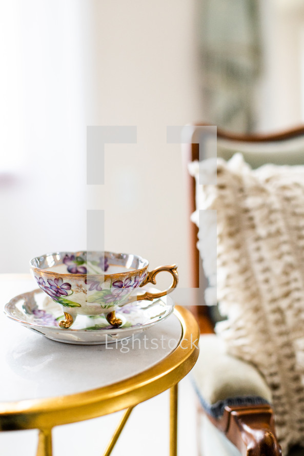 tea cup on a side table next to a chair 