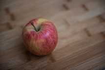 top view of one rustic apple on a wooden background