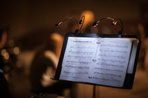 lights on a music stand illuminating sheet music 