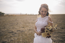 a bride holding a bouquet of fall flowers 