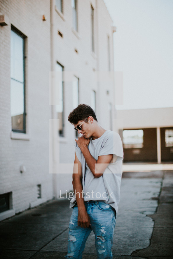 young man posing in an alley 