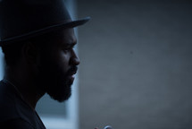 side profile of an African American man with a beard wearing a hat 